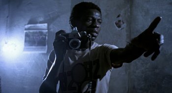 Movie still from “City of God” (2002), directed by Kátia Lund – A man holding a camera in a dark room; Close Up shot, Low angle