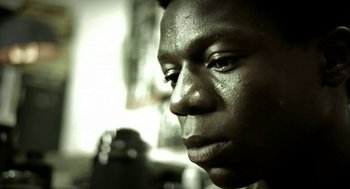 Movie still from “City of God” (2002), directed by Kátia Lund – A man's face in black - and - white; Extreme Close Up shot, Low angle