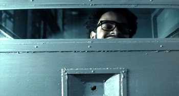 Movie still from “City of God” (2002), directed by Kátia Lund – A man wearing glasses looking out of a train window; Close Up shot, Low angle