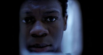 Movie still from “City of God” (2002), directed by Kátia Lund – A man's face in the dark; Extreme Close Up shot, Overhead angle