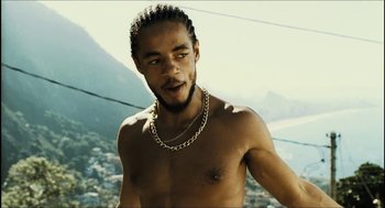 Movie still from “City of Men” (2007), directed by Paulo Morelli – A man with a beard is posing for a picture; Close Up shot, Low angle