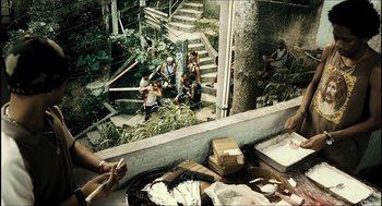 Movie still from “City of Men” (2007), directed by Paulo Morelli – A group of people sitting on steps near a forest; Wide shot, High angle