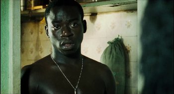 Movie still from “City of Men” (2007), directed by Paulo Morelli – A man with a necklace standing in a bathroom; Close Up shot, High angle