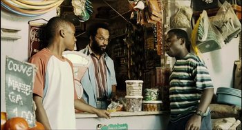 Movie still from “City of Men” (2007), directed by Paulo Morelli – A group of people standing around a store; Medium shot, Over the shoulder angle