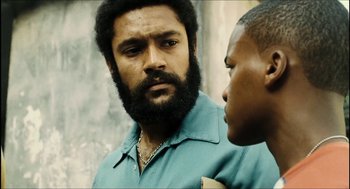 Movie still from “City of Men” (2007), directed by Paulo Morelli – A man with a beard is looking at another man with a beard; Close Up shot, Low angle