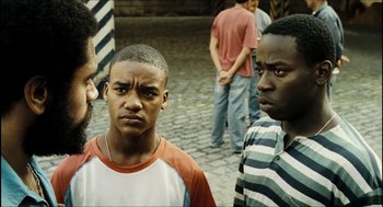 Movie still from “City of Men” (2007), directed by Paulo Morelli – A group of young men standing next to each other on a street; Medium shot, Over the shoulder angle