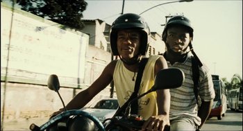 Movie still from “City of Men” (2007), directed by Paulo Morelli – Two young men on a motor scooter on a city street; Medium shot, Low angle