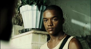 Movie still from “City of Men” (2007), directed by Paulo Morelli – A young man is standing in front of a potted plant; Close Up shot, Low angle