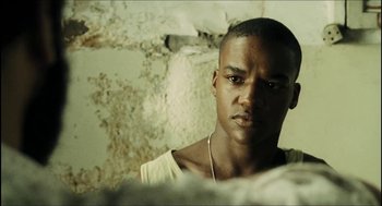 Movie still from “City of Men” (2007), directed by Paulo Morelli – A man with a necklace is looking into the distance; Close Up shot, Low angle