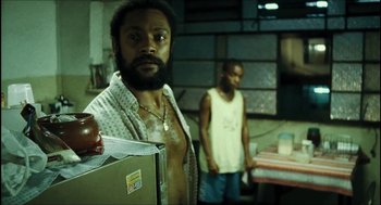 Movie still from “City of Men” (2007), directed by Paulo Morelli – A man standing next to another man in a room; Medium shot, Low angle