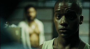 Movie still from “City of Men” (2007), directed by Paulo Morelli – A man standing next to another man in a dark room; Close Up shot, Low angle