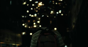 Movie still from “City of Men” (2007), directed by Paulo Morelli – A person with a backpack looking out at the city lights at night; Extreme Wide shot, Low angle
