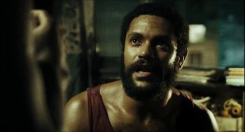 Movie still from “City of Men” (2007), directed by Paulo Morelli – A man with a beard is looking at the camera; Close Up shot, Over the shoulder angle