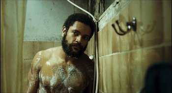 Movie still from “City of Men” (2007), directed by Paulo Morelli – A bearded man taking a shower in a bathroom; Close Up shot, Low angle