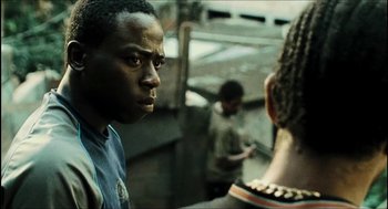 Movie still from “City of Men” (2007), directed by Paulo Morelli – A man standing next to another man in a room; Close Up shot, Over the shoulder angle