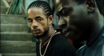 Movie still from “City of Men” (2007), directed by Paulo Morelli – A man in a black shirt and a man in a gold chain; Close Up shot, Over the shoulder angle