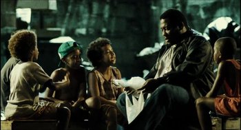 Movie still from “City of Men” (2007), directed by Paulo Morelli – A man sitting next to two young children; Medium shot, High angle