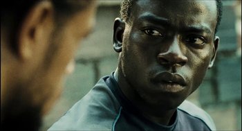 Movie still from “City of Men” (2007), directed by Paulo Morelli – A man's face in a green shirt; Close Up shot, Over the shoulder angle