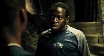 Movie still from “City of Men” (2007), directed by Paulo Morelli – A man in a blue shirt is looking at the camera; Close Up shot, Over the shoulder angle