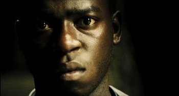 Movie still from “City of Men” (2007), directed by Paulo Morelli – A man's face in the dark; Close Up shot, Low angle