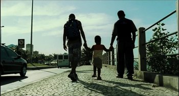 Movie still from “City of Men” (2007), directed by Paulo Morelli – Two men and a child walking down a street; Wide shot, Low angle