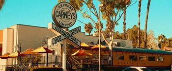 Movie still from “Day Shift” (2022), directed by J.J. Perry – A sign for a restaurant in front of a building; Extreme Wide shot, Low angle