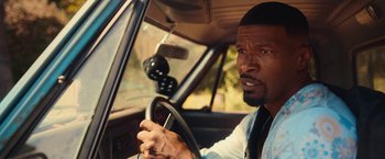 Movie still from “Day Shift” (2022), directed by J.J. Perry – A person in a car holding a steering wheel; Close Up shot, Over the shoulder angle