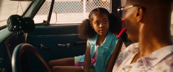 Movie still from “Day Shift” (2022), directed by J.J. Perry – A girl sitting in the back seat of a car; Close Up shot, Over the shoulder angle