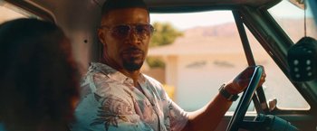 Movie still from “Day Shift” (2022), directed by J.J. Perry – A man in a floral shirt driving a car; Close Up shot, Over the shoulder angle