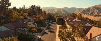 Movie still from “Day Shift” (2022), directed by J.J. Perry – An aerial view of a street with cars driving down it; Extreme Wide shot, High angle