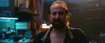 Movie still from “Day Shift” (2022), directed by J.J. Perry – A man with long hair and a beard; Close Up shot, Over the shoulder angle