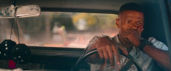 Movie still from “Day Shift” (2022), directed by J.J. Perry – A man sitting in the driver's seat of a car; Close Up shot, Over the shoulder angle