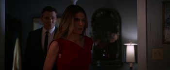 Movie still from “Day Shift” (2022), directed by J.J. Perry – A woman in a red dress standing next to a man in a suit; Medium shot, Over the shoulder angle