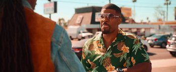 Movie still from “Day Shift” (2022), directed by J.J. Perry – A man wearing a hawaiian shirt and sunglasses; Medium shot, Over the shoulder angle