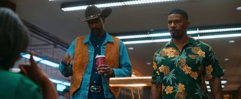 Movie still from “Day Shift” (2022), directed by J.J. Perry – A man in a cowboy hat holding a drink; Medium shot, Low angle