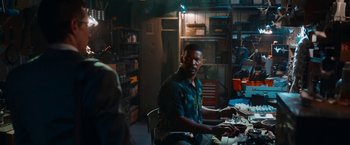 Movie still from “Day Shift” (2022), directed by J.J. Perry – A man sitting at a table in a room; Medium shot, Over the shoulder angle