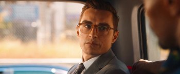 Movie still from “Day Shift” (2022), directed by J.J. Perry – A person wearing a suit and glasses; Close Up shot, Over the shoulder angle
