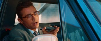 Movie still from “Day Shift” (2022), directed by J.J. Perry – A man sitting in the driver's seat of a car holding a cell phone; Close Up shot, Over the shoulder angle