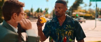 Movie still from “Day Shift” (2022), directed by J.J. Perry – A man holding a glass of orange juice in his right hand; Close Up shot, Over the shoulder angle