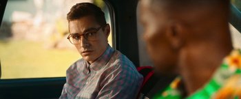 Movie still from “Day Shift” (2022), directed by J.J. Perry – A man sitting in the back seat of a car; Close Up shot, Over the shoulder angle