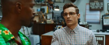 Movie still from “Day Shift” (2022), directed by J.J. Perry – A man wearing glasses and a checkered shirt; Close Up shot, Over the shoulder angle