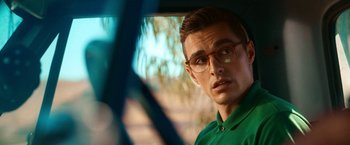 Movie still from “Day Shift” (2022), directed by J.J. Perry – A young man wearing glasses and a green shirt; Close Up shot, Over the shoulder angle