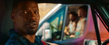 Movie still from “Day Shift” (2022), directed by J.J. Perry – A person in a car on the road; Close Up shot, Over the shoulder angle