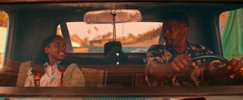 Movie still from “Day Shift” (2022), directed by J.J. Perry – A man sitting in the back seat of a car; Medium shot, Over the shoulder angle