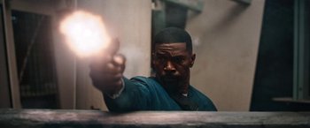 Movie still from “Day Shift” (2022), directed by J.J. Perry – A man holding a gun in his hand; Close Up shot, Low angle