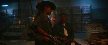 Movie still from “Day Shift” (2022), directed by J.J. Perry – Two men holding guns and standing next to each other; Medium shot, Over the shoulder angle