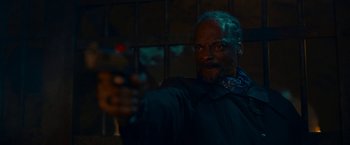 Movie still from “Day Shift” (2022), directed by J.J. Perry – A man holding a gun in a dark room; Close Up shot, Low angle