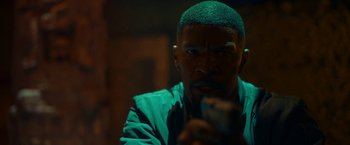 Movie still from “Day Shift” (2022), directed by J.J. Perry – A person holding a gun in a dark room; Close Up shot, Low angle