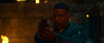Movie still from “Day Shift” (2022), directed by J.J. Perry – A man holding a gun while standing in the dark; Close Up shot, Over the shoulder angle