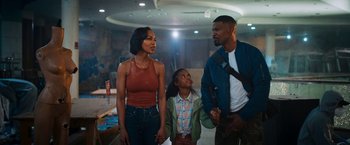 Movie still from “Day Shift” (2022), directed by J.J. Perry – A man , woman , and child are standing together; Medium shot, Over the shoulder angle